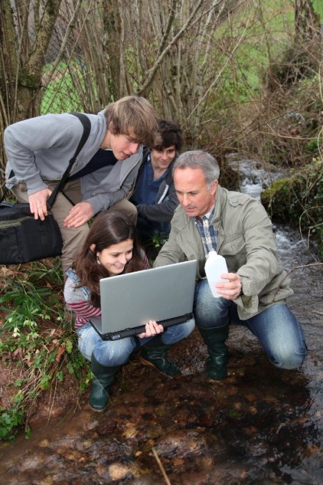 Group of students doing river studies with teacher